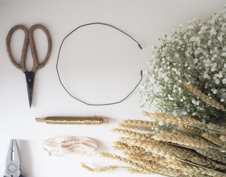 table avec ciseaux fil de fer paille fleurs pour faire une couronne de fleurs