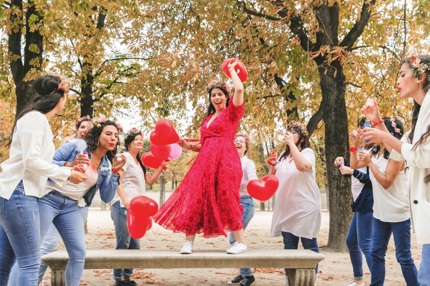 shooting evjf a paris amies avec des ballons qui s'amusent la mariée est debout sur un banc