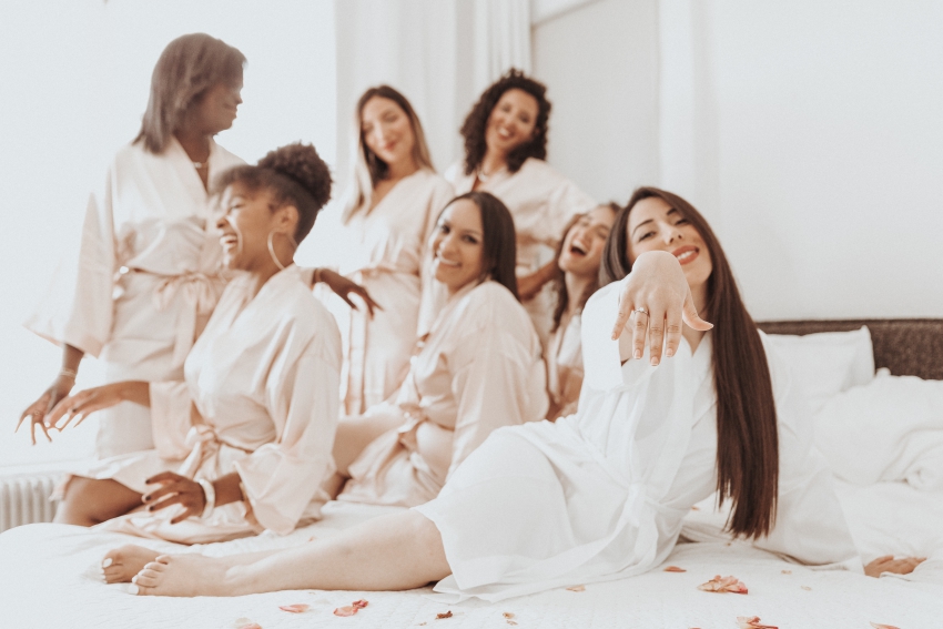groupe de femmes sur un lit avec une mariee qui montre sa bague de mariage groupe de femmes sur un lit avec une mariee qui montre sa bague de mariage