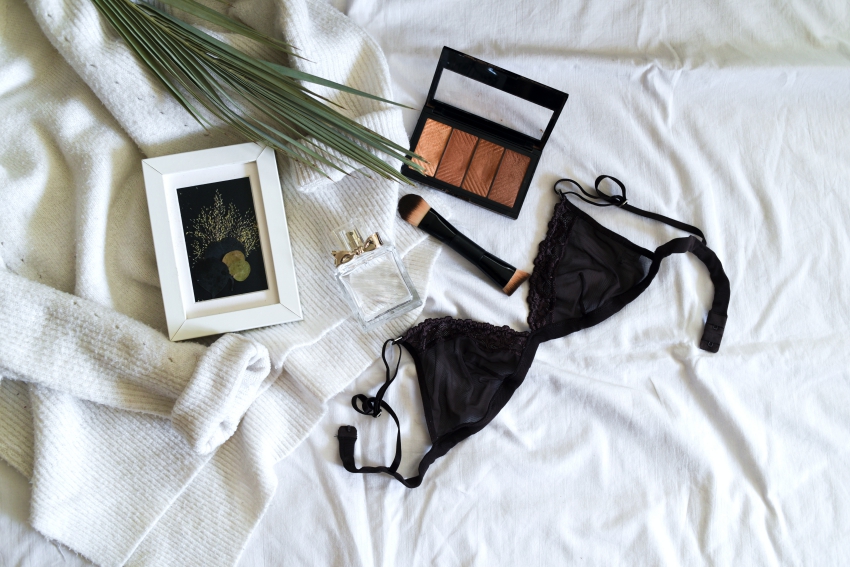 soutien gorge noir et palette de maquillage sur un drap blanc soutien gorge noir et palette de maquillage sur un drap blanc